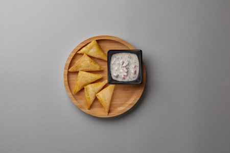 on gray background on a wooden plate there are in the shape of a triangle with white sauce quick snackの写真素材