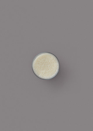 top shot on a gray background glass glass with milk childrens favorite drink spiced milk from cows minimalism addition to many dishesの写真素材