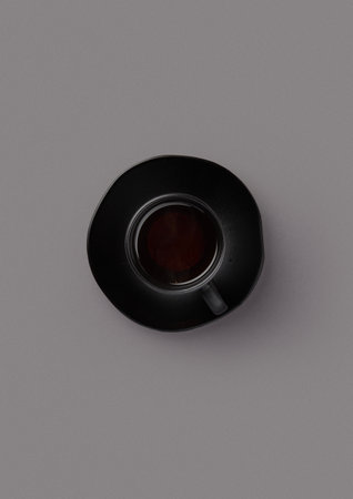 top shot on gray background black saucer in a small black cup black tea english breakfast evening drinkの写真素材