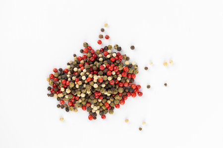 on white background a pile of mixed large aromatic peppers black red and white the main seasoning...