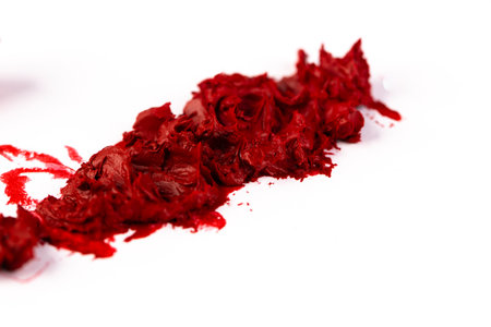 Vibrant Red Paint Spread Across a White Surface: An Artistic Display of Texture and Color Play Perfect for Inspirational Projects and Designsの写真素材