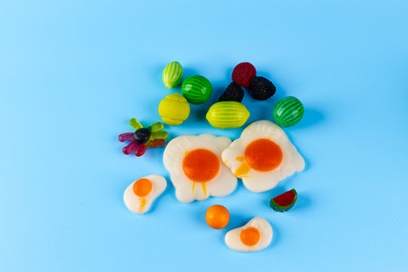 A Colorful Display of Fruit and Candy with Edible Egg Shapes on a Bright Blue Background, Perfect...