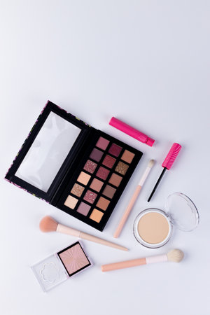 A Beautiful Arrangement of Modern Makeup Essentials Including an Eyeshadow Palette, Brushes, and Lip Products Perfect for Creating Stunning Looks and Stylesの写真素材