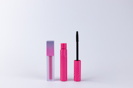 Stylish and Vibrant Pink Makeup Products Showcasing a Glossy Lipstick and Eye-Catching Mascara Perfect for Fashion Enthusiasts and Makeup Loversの写真素材