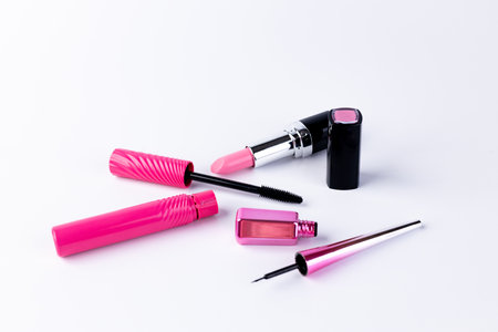 Vibrant Collection of Pink Cosmetics Including Lipstick, Mascara, and Nail Polish Laid Out Against a Clean White Background for an Eye-Catching Visual Appealの写真素材