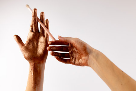Artistic Hands Aesthetics Featuring Glittering Bronze Pigment and Makeup Brush, Emphasizing Beauty and Creativity in Makeup Application and Artistic Expression in Unique Styleの写真素材