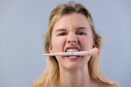 A Playful Moment Captured: A Young Womans Quirky Expression with a Makeup Brush in Her Mouth...