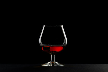 Elegant Glass of Amber Liquid in Dram Glass Captured Against a Dark Background Perfect for Social Media Posts or Connoisseur Articlesの写真素材