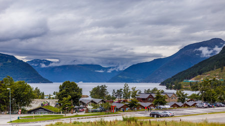 Stunning Landscape of Norwegian Fjord: Serene Waters and Majestic Mountains Under Cloudy Skiesの写真素材