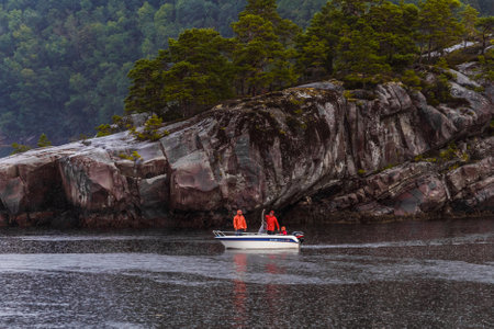 Exploring Serene Waters: A Boat Adventure Amidst Dramatic Rocky Landscapes and Lush Greenery in a Tranquil Coastal Settingの写真素材