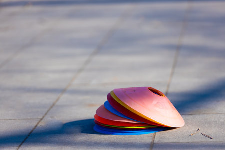 Colorful Stacked Training Cones on a Paved Surface: Perfect for Sports Drills, Obstacle Courses, and Outdoor Play Activities, Inviting Fun and Fitnessの写真素材