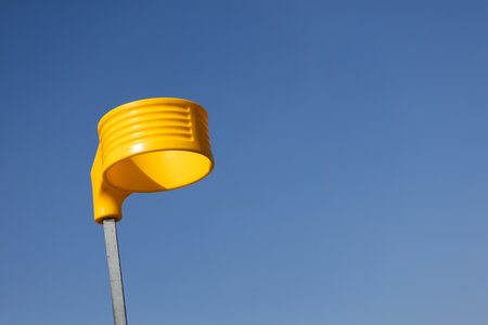 A Bright and Cheerful Yellow Object Stands Out Against a Clear Blue Sky, Showcasing a Unique Design That Captures the Eye with Its Vibrant Color and Distinct Shapeの写真素材