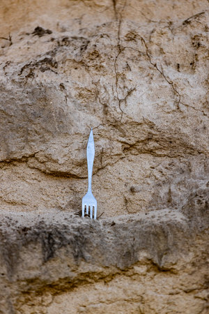 A Surprising Encounter: A Single Fork Balanced on an Earthy Surface Creates a Unique Visual Contrast in Natures Raw Beautyの写真素材