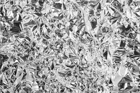 Shiny metal silver foil texture for background. White gray gray festive metallic backdrop. Glamor christmas wallpaper. New year, christmas, industrial texture.の写真素材