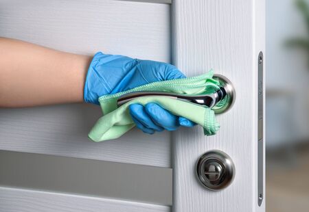 Sterile cleaning of door handles during a coronavirus pandemic. Alcohol-based cleaner, gloves and a...