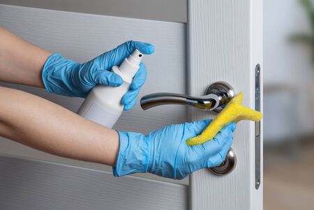 Cleaning door handles with an antiseptic during a viral epidemicの写真素材