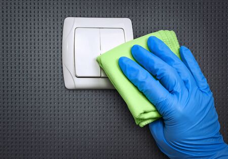 Cleaning the house. Disinfecting surfaces in the home to prevent coronavirus infection. Cleaning the light switch.の写真素材