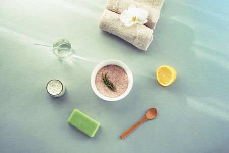 Himalayan salt in a bowl for skin care treatment. Lemon, organic soap and towel. Natural cosmetics and spa concept. Top view, flat lay.の写真素材