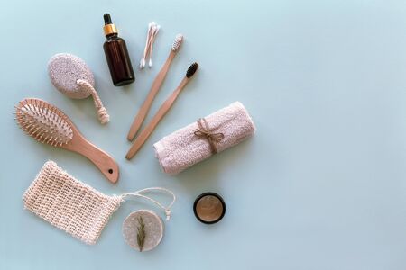 Natural cosmetics, soap, wooden toothbrushes, cosmetic mittens, comb and moisturizer on a blue table. Beauty, spa and wellness. Zero waste concept. Copy space.の写真素材