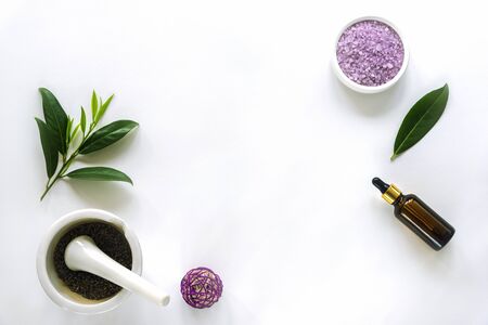 Fresh tree leaves, mortar and pestel, lavender bath salt on white background, top view, copy space. Natural handmade cosmetics conceptの写真素材