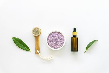 Cosmetic face brush, lavender scrub and skin serum in a bottle on white background. Natural cosmetics concept, zero waste. Top view, falt lay.の写真素材