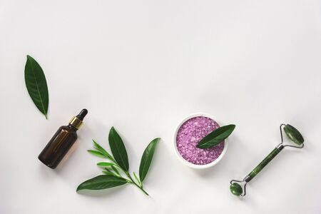 Modern apothecary, natural ingredients. Oil made of herbs, lavender bath salt and face roller. Top view, flat layの写真素材