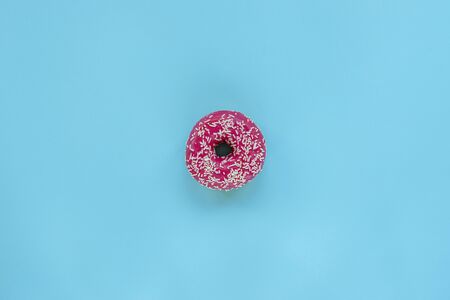 Pink donut on blue background, top view, flat layの写真素材