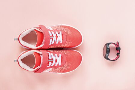 Red sneakers and sport watch on pink background. Concept of healthy life, sport and training, top view, flat layの写真素材