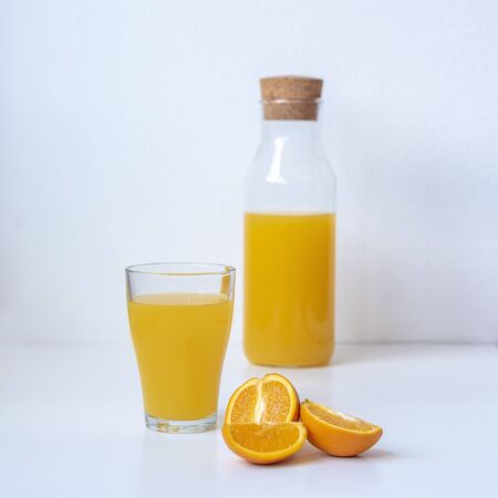 Orange juice in a glass and fruits on white background, close up. Healthy foodの写真素材