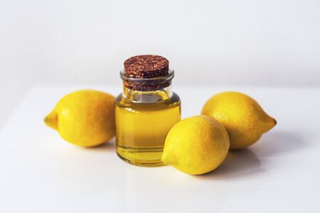 Lemon essential oil and fruits on white background. Natural cosmetics and aromatherapy concept....