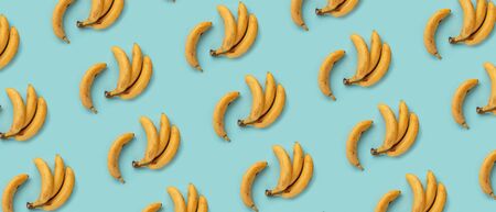 Yellow bananas on turquoise background, texture. Summer concept. Flat layの写真素材