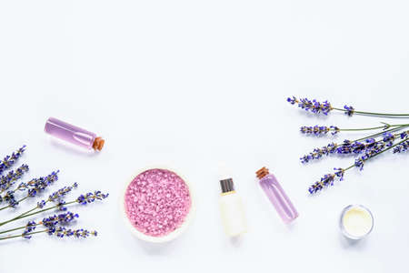 Lavender blossom, sea salt, cream jar, serum and essential oils on white background, top view, flat lay.の写真素材