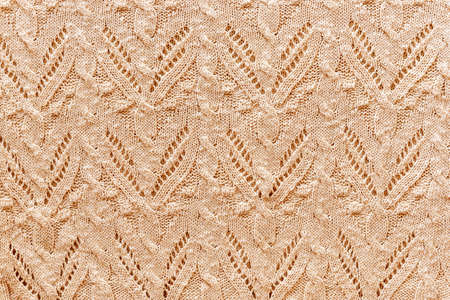 Beautiful beige abstract knitted background, texture. Autumn comfort clothes