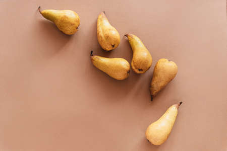 Yellow pears on brown background. Flat lay, top view, copy space.
