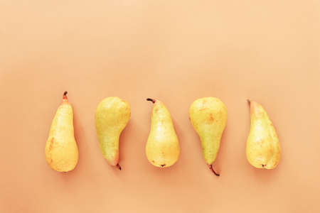 Yellow pears on beige background, top view, flat lay.の写真素材