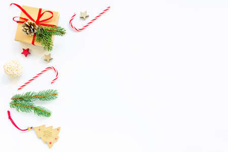 Christmas layout made of fir branches, red candy, gift in box, decorations. Christmas or New Year background. Flat lay, top view, copy space.の写真素材