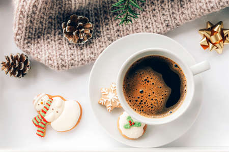 A cup of coffee with gingerbread, a spruce branch, pine cones and a knitted plaid. New Year and Christmas holidays concept. Top view, flat lay.の写真素材