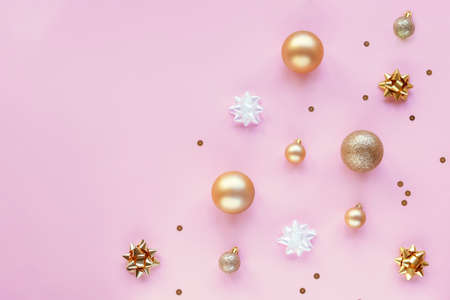 Pink festive background with golden Christmas balls, tinsel and baubles. Top view, flat lay, copy space.の写真素材