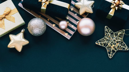 New Year gifts in black and golden boxes and Christmas toys on black background. Top view, flat lay, copy space.の写真素材
