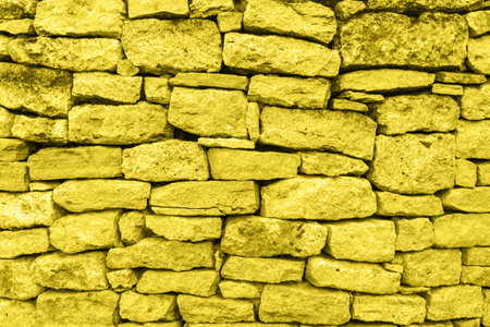 Yellow stone wall. Texture, background Trendy color 2021の写真素材