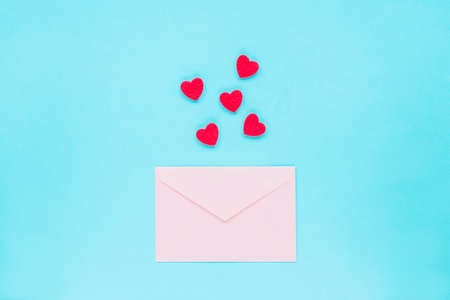 Pink envelope and red hearts on a blue background, top view, flat lay. Valentines day concept, 14...