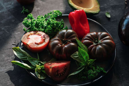 Bio organic vegetables on black chalkboard background, healthy raw vegan food concept. Shallow depth of field.の写真素材