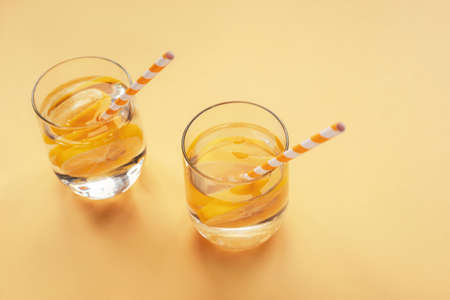 Two glasses of lemonade with straws on a yellow background, top view.の写真素材