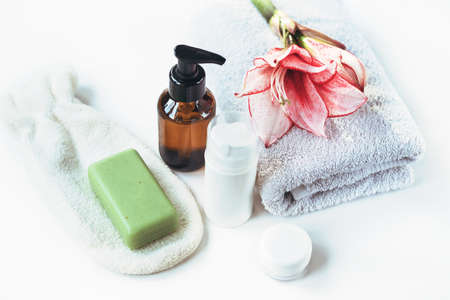 Cosmetics, skin tonic, towel and handmade soap on white table. Spa treatments and skin care concept.の写真素材