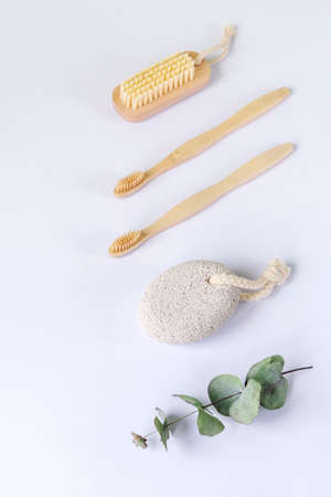 Toiletries on white background. Pumice stone, tothbrushes and body brush, eucalyptus leaves. Plastic free and zero waste concept. Top viewの写真素材