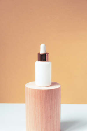 Natural essential oil or serum in white bottle on a wooden podium. Alternative medicine, beauty skin care product. Copy spaceの写真素材