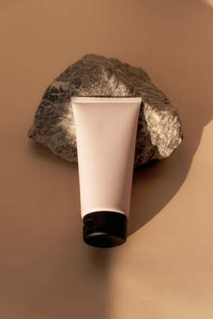 Cream tube on natural stone on neutral background, top view, flat lay. Mock upの写真素材