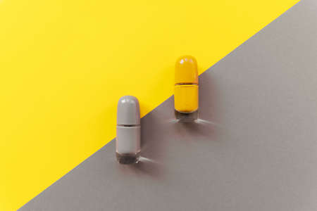 Yellow and gray nail polishes on a two-tone background. Trendy colors of the year 2021. Top view, flat lay.の写真素材