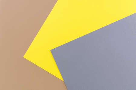 Beige, yellow and gray colored paper. Geometric empty paper background of three tones, copy space.