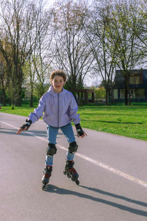 Happy ten years old girl rollerblading in the park in sunny day.